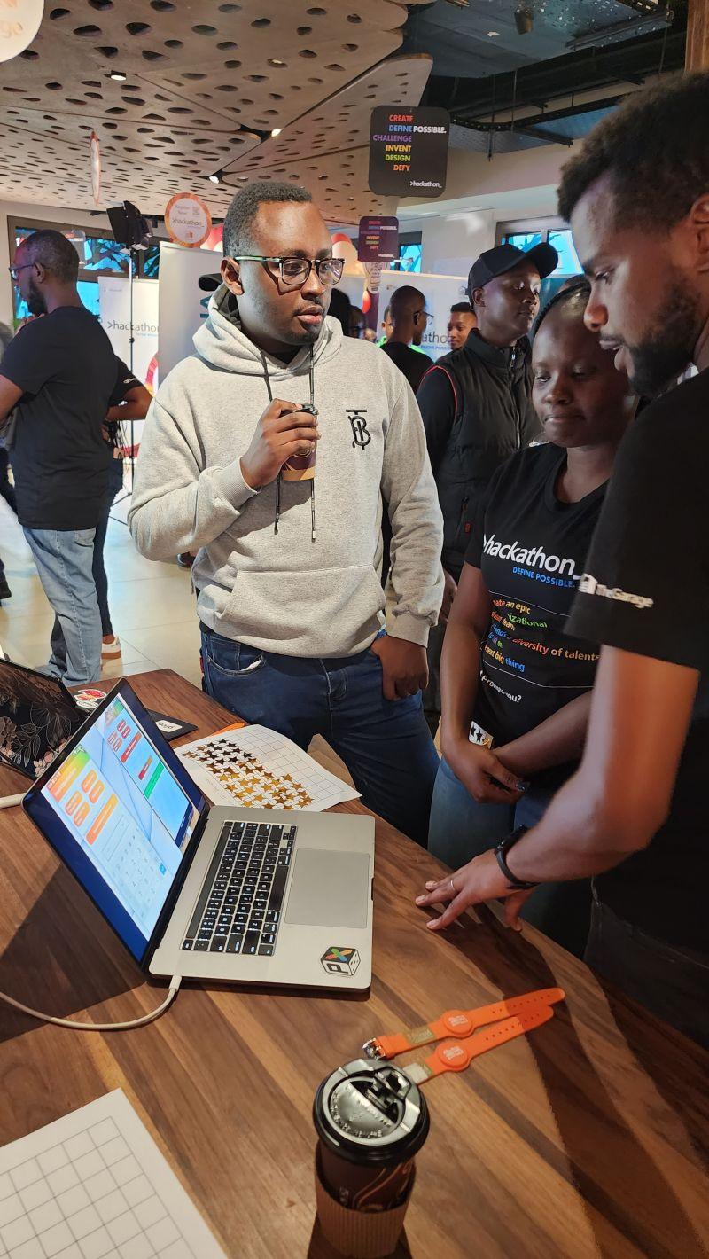Demo table at the Microsoft hackathon, with orange Tap2Eat wristbands beside a laptop